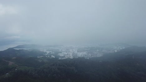 Aerial-view-the-Sungai-Ara-town-from-foggy-sky-and-green-forest.